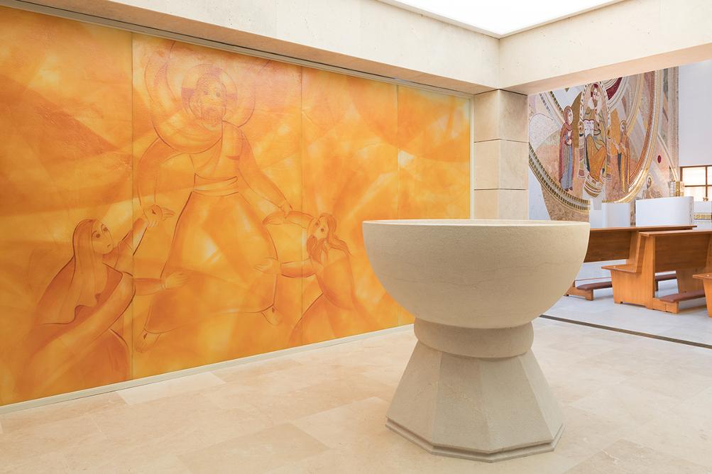 Room lined with stone, with a painted glass wall and stone baptistery. 